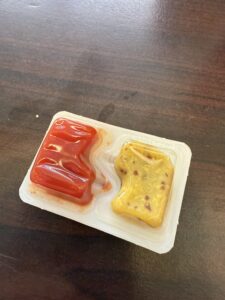 A combined packet of ketchup and mustard
