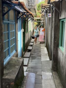 Narrow alleyway at Four Four South Village. Two humans stand at a distance for scale.