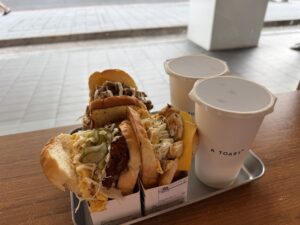 A tray of three sandwiches and two drinks